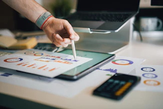 person using stylus on tablet with charts