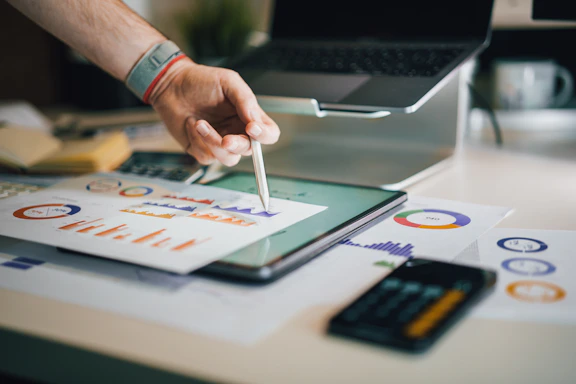 person using stylus on tablet with charts