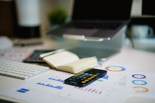 A desk with financial paperwork and a laptop