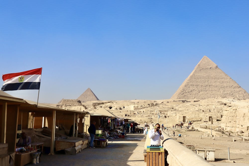 a woman taking a picture of the pyramids in egypt