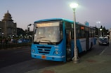 a blue bus parked on the side of the road