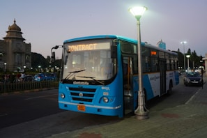 a blue bus parked on the side of the road