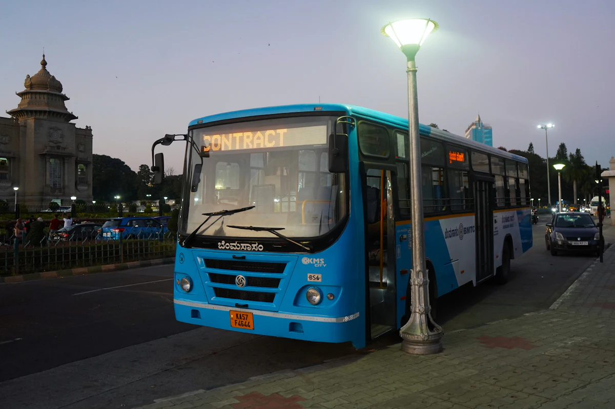 A city bus waiting at a stop in the evening