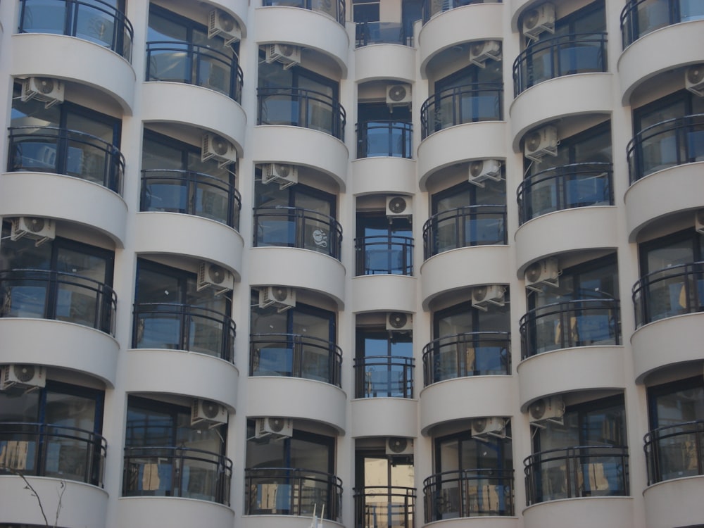 a tall white building with balconies and balconies