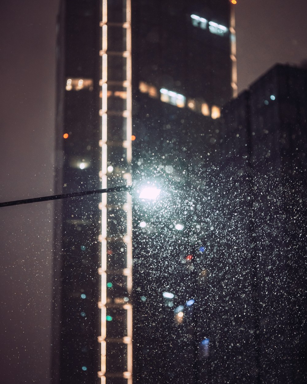 a view of a tall building at night through a window