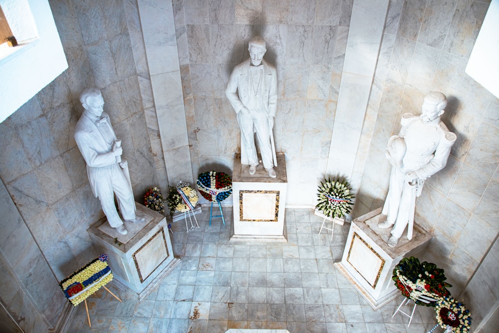 a group of statues in a room with a tiled floor