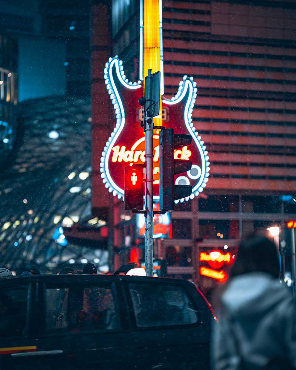 a neon guitar sign on the side of a building