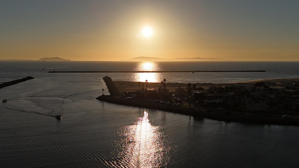 a large body of water with a sunset in the background