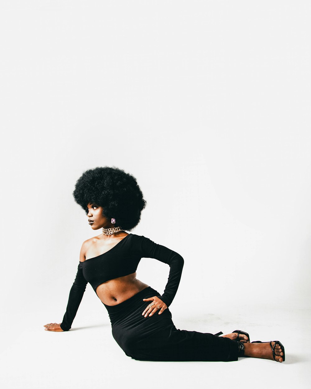 a woman with an afro sitting on the ground