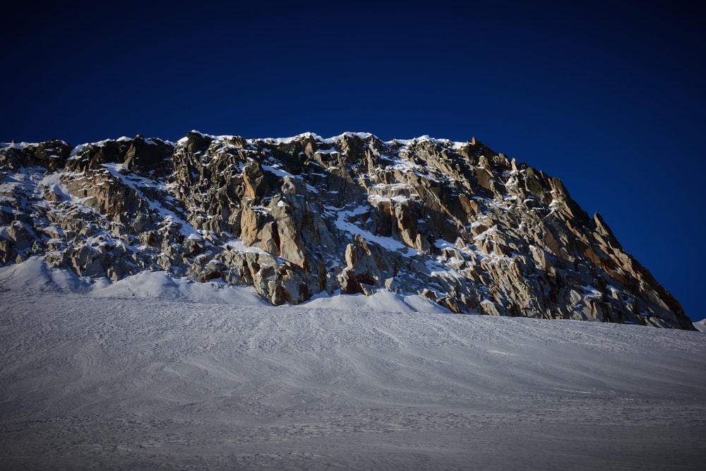 ein großer, schneebedeckter Berg unter blauem Himmel