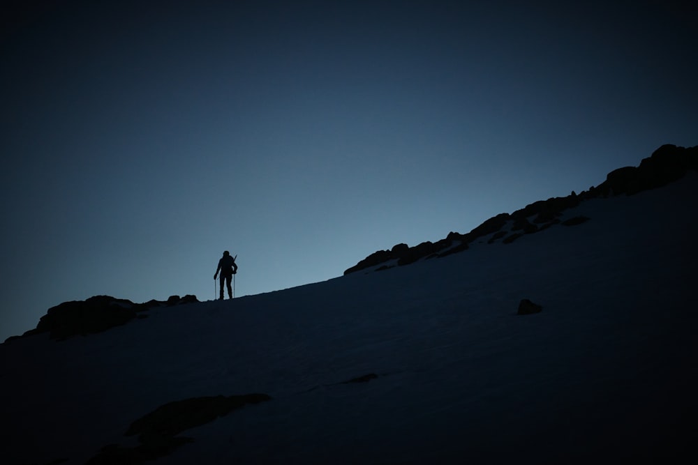 a person standing on top of a snow covered slope