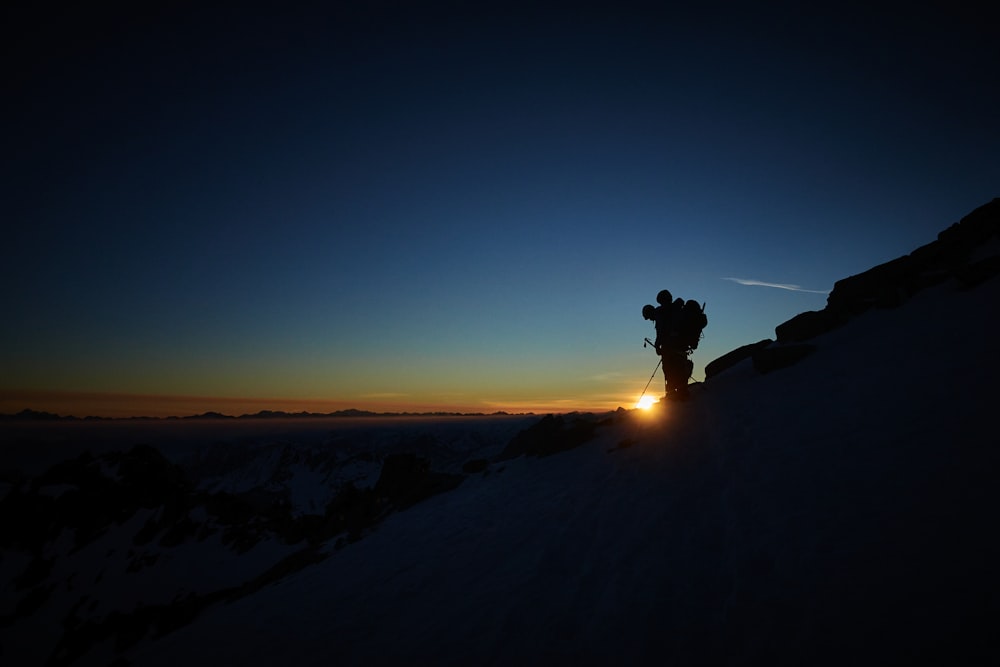 uma pessoa em pé no topo de uma encosta coberta de neve