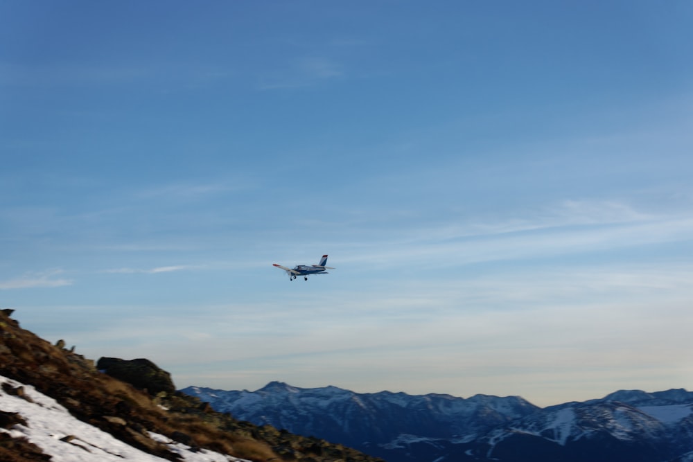 Ein Flugzeug fliegt über einen verschneiten Berg