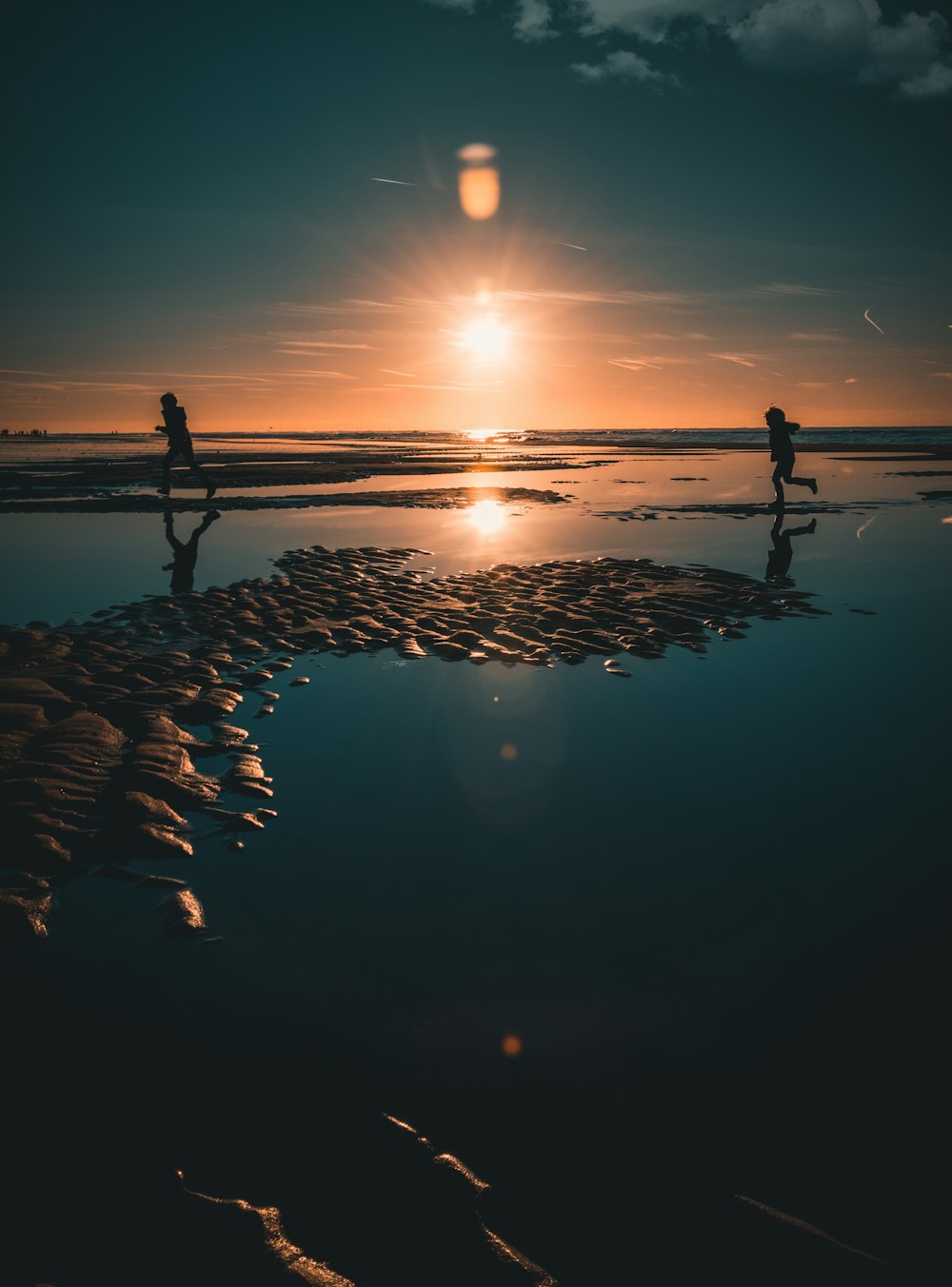 a couple of people standing on top of a beach