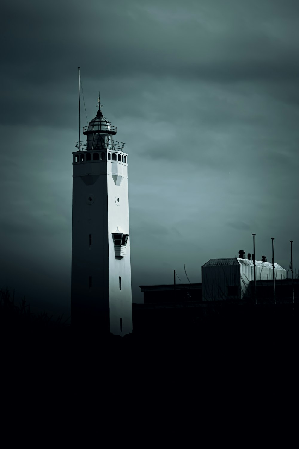 una alta torre blanca con una luz en la parte superior