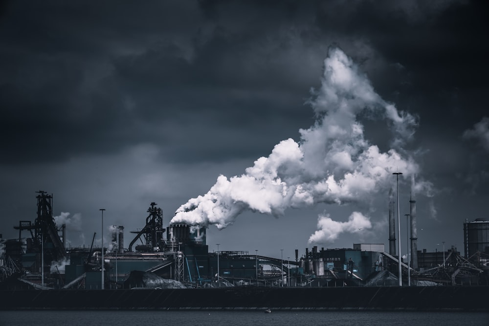 uma foto em preto e branco de uma fábrica com chaminés de fumaça