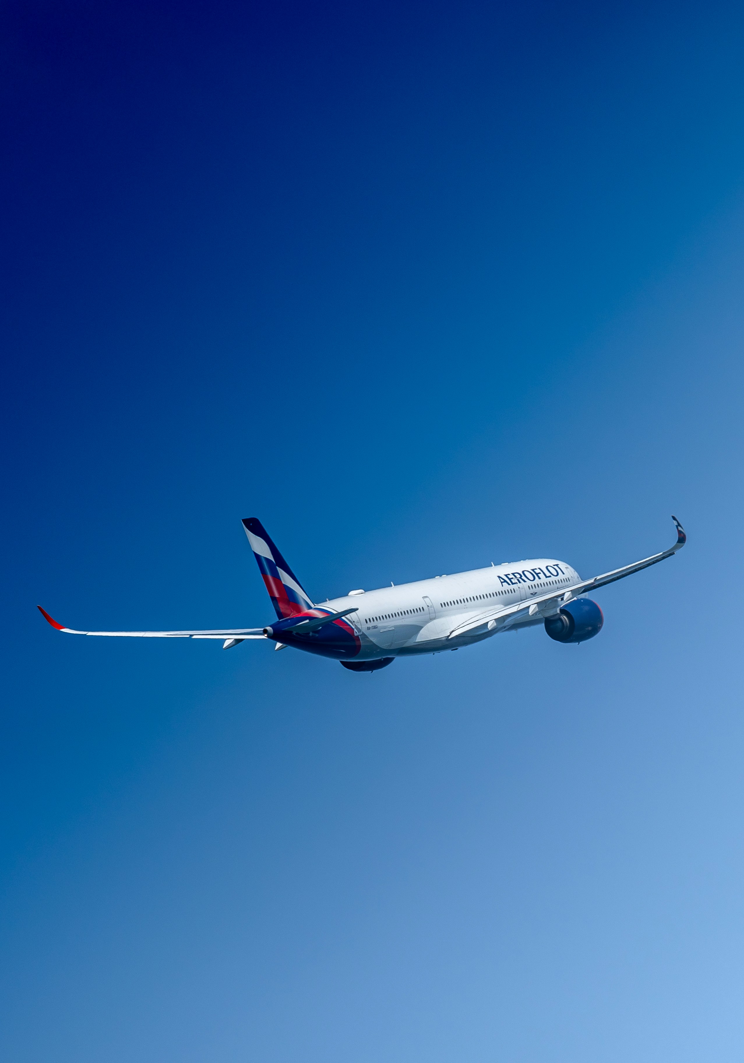 a large commercial airplane flying through a blue sky