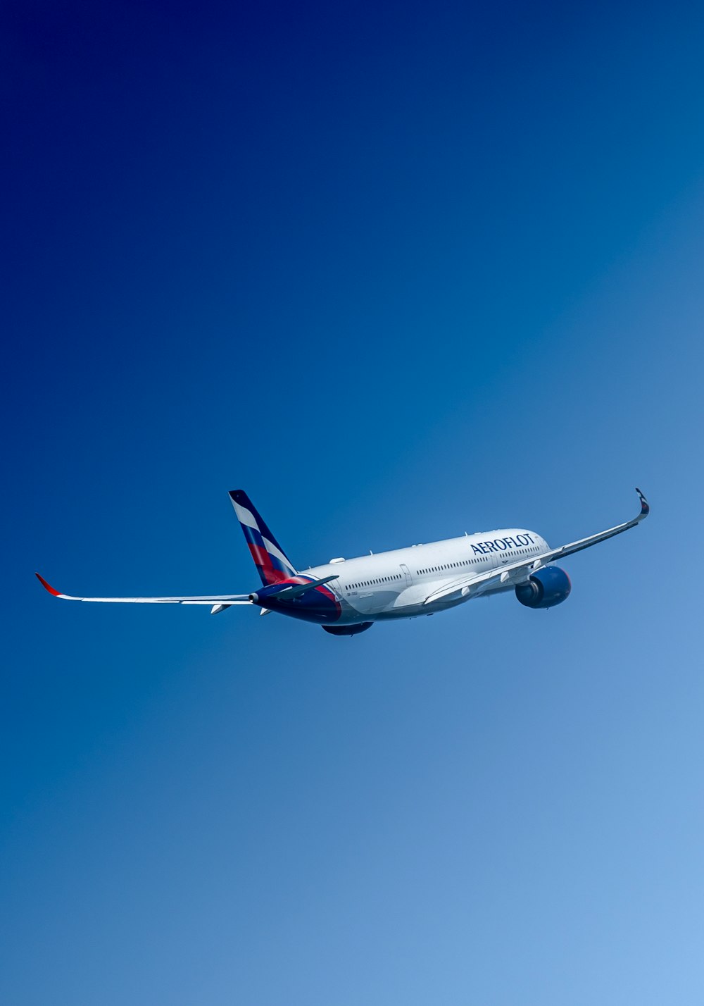 a large commercial airplane flying through a blue sky