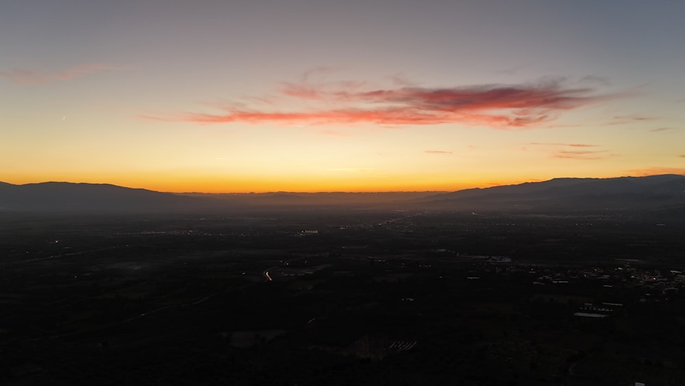 the sun is setting over a mountain range