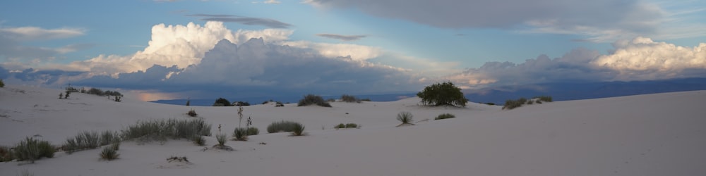 the sun is shining through the clouds over the sand dunes