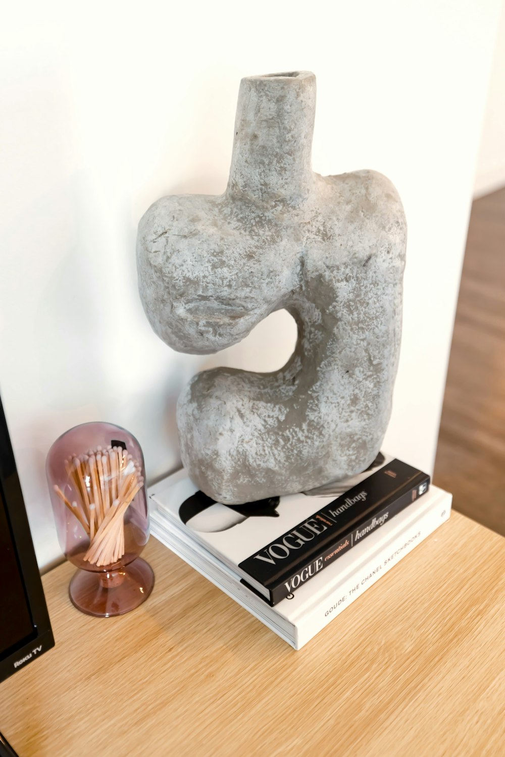 a table with a book and a sculpture on top of it
