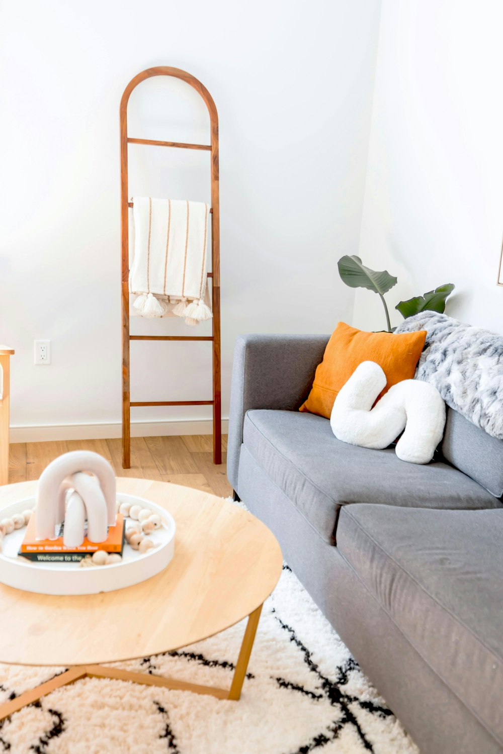 a living room with a gray couch and a white rug