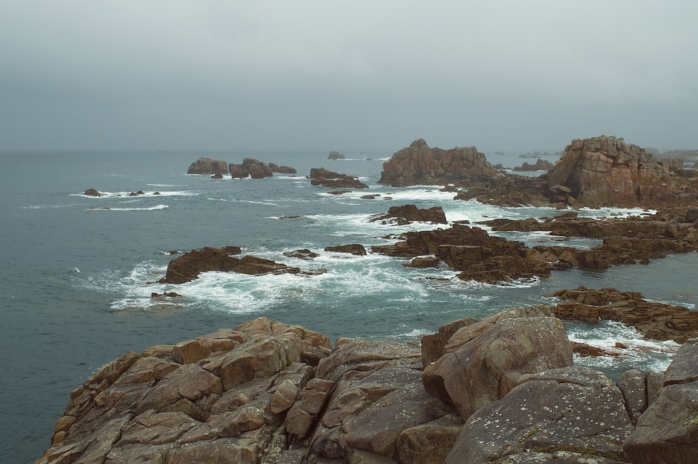 a view of a rocky coast with waves crashing on the rocks