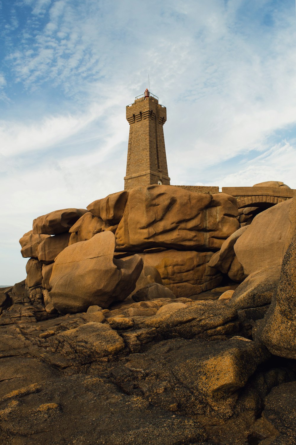 a lighthouse on top of a rocky outcropping