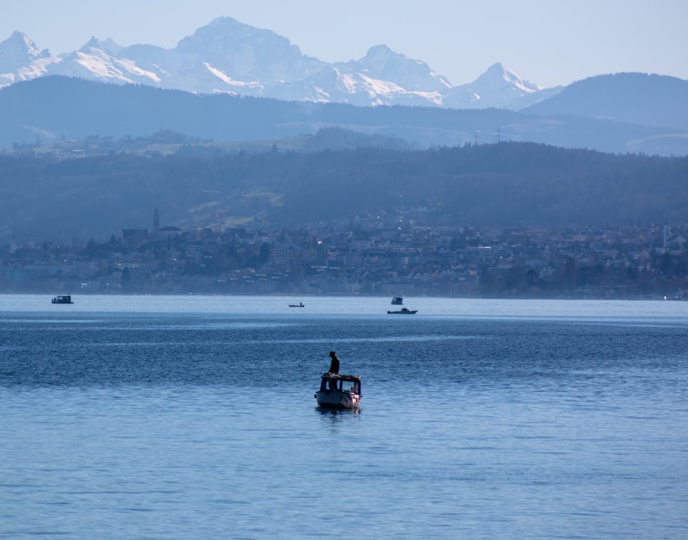 a man on a boat in the middle of a lake