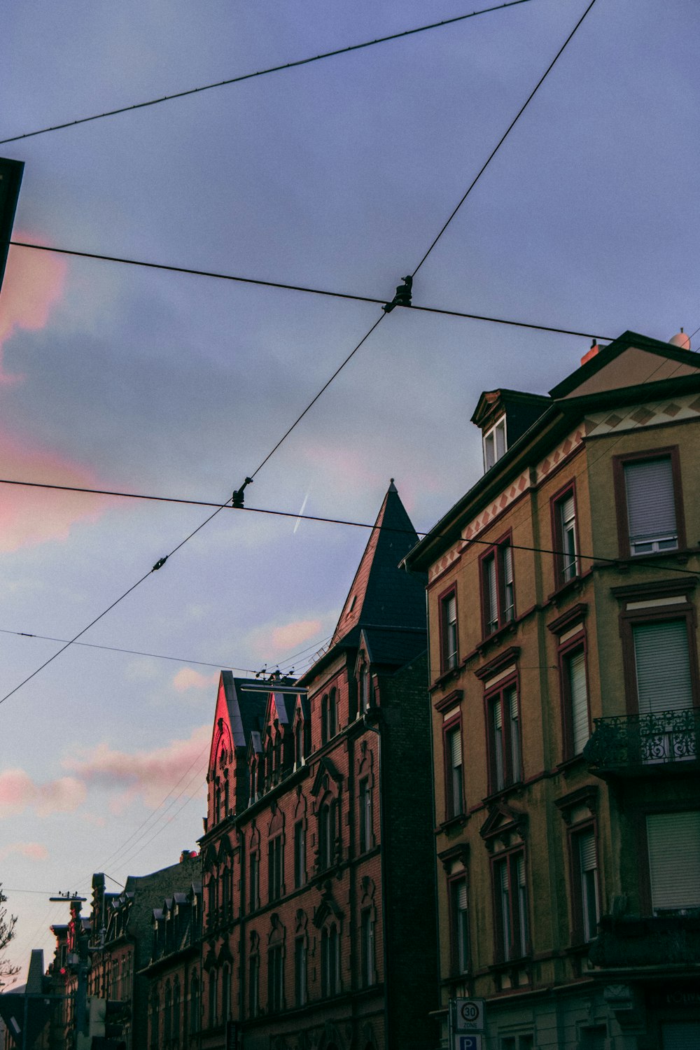 a row of buildings on a city street under a cloudy sky