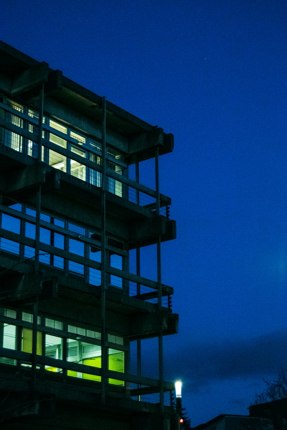 a tall building lit up at night with a clock tower in the background