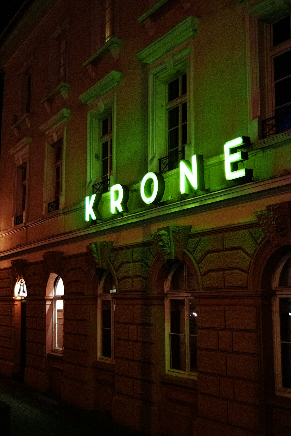 a building with a neon sign that reads krone