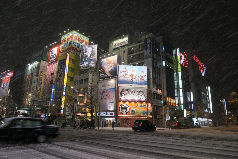 a busy city street at night in the snow