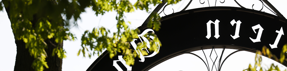 a black and white sign with trees in the background