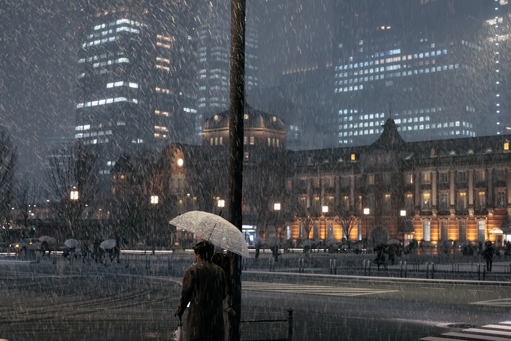 a person standing under an umbrella in the rain