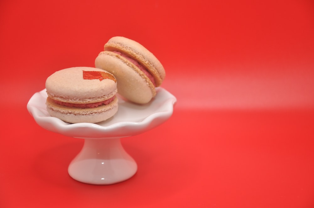 a small white plate with two macaroons on it