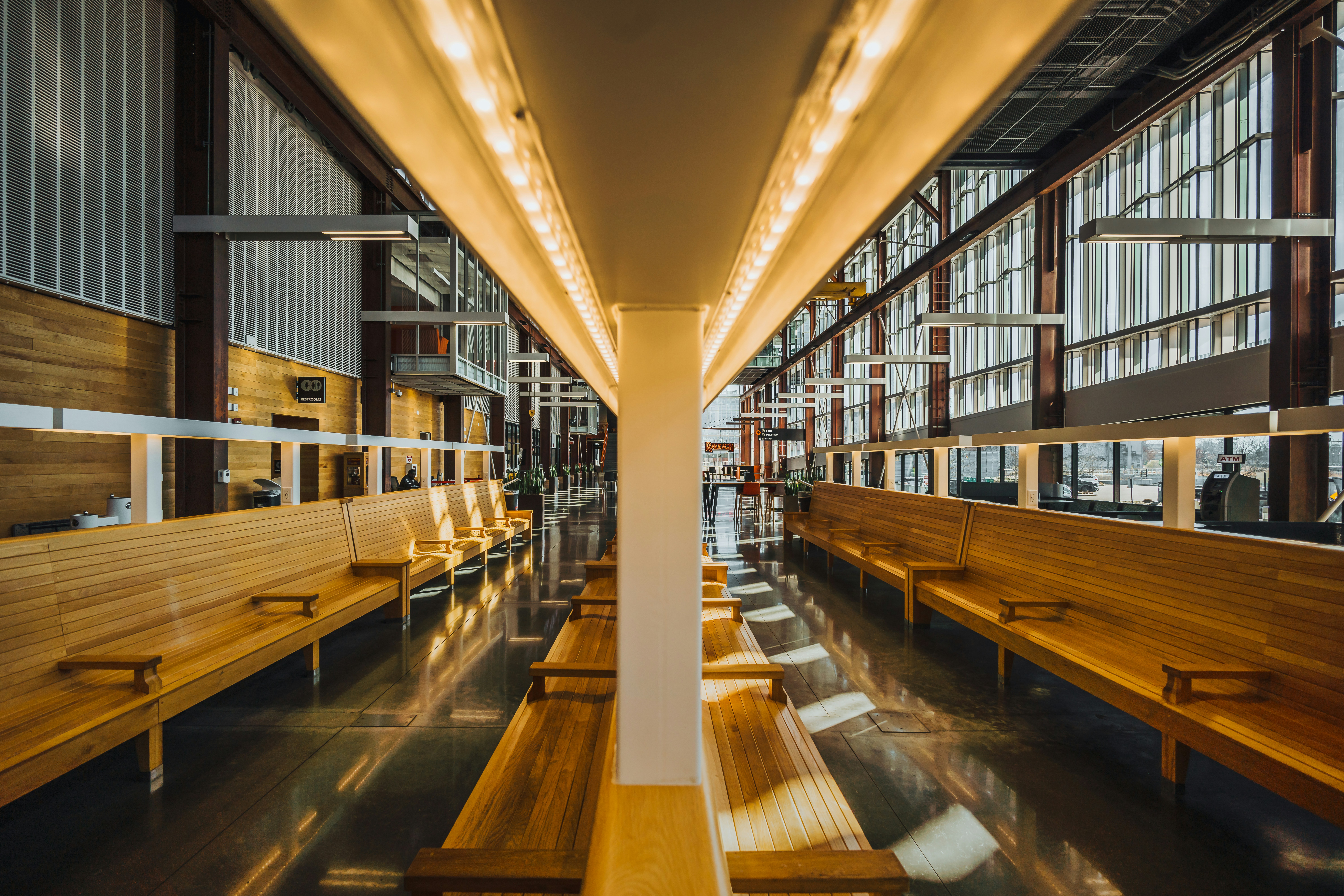 a row of wooden benches sitting inside of a building