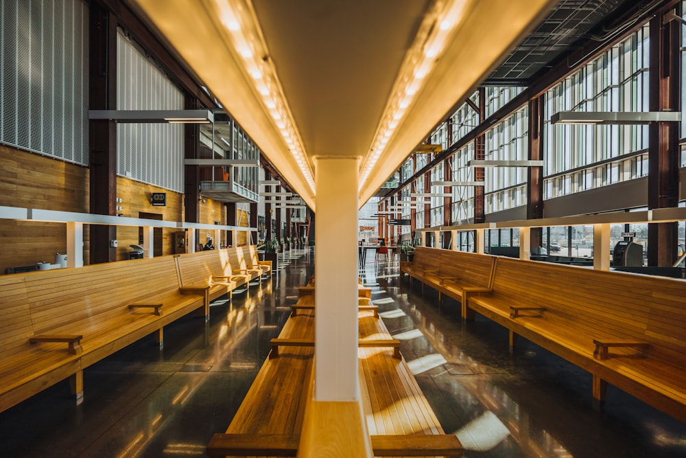 a row of wooden benches sitting inside of a building
