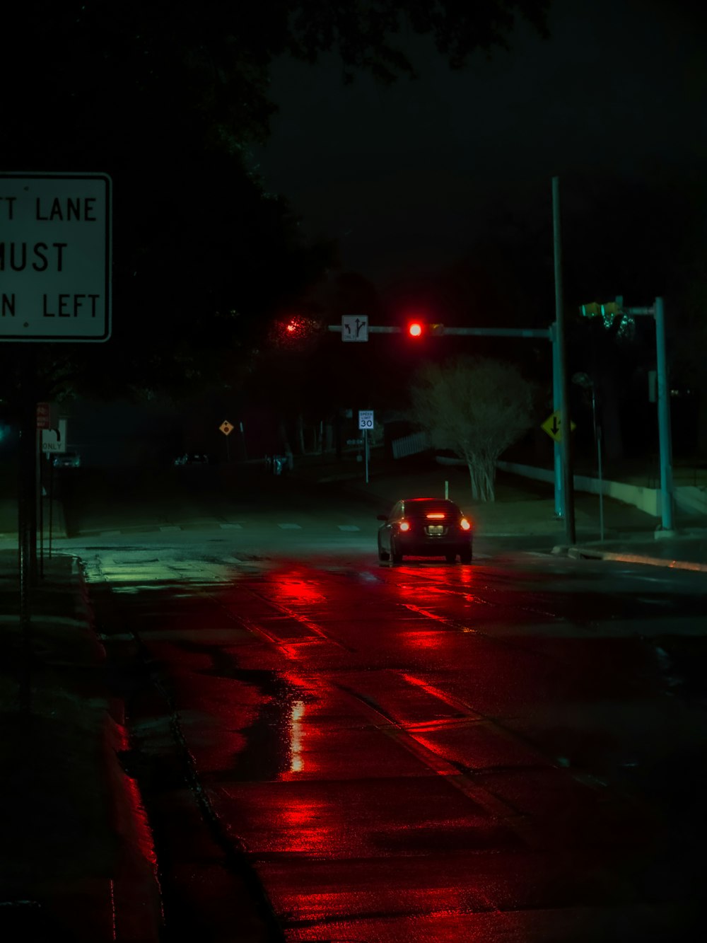 a car driving down a street at night