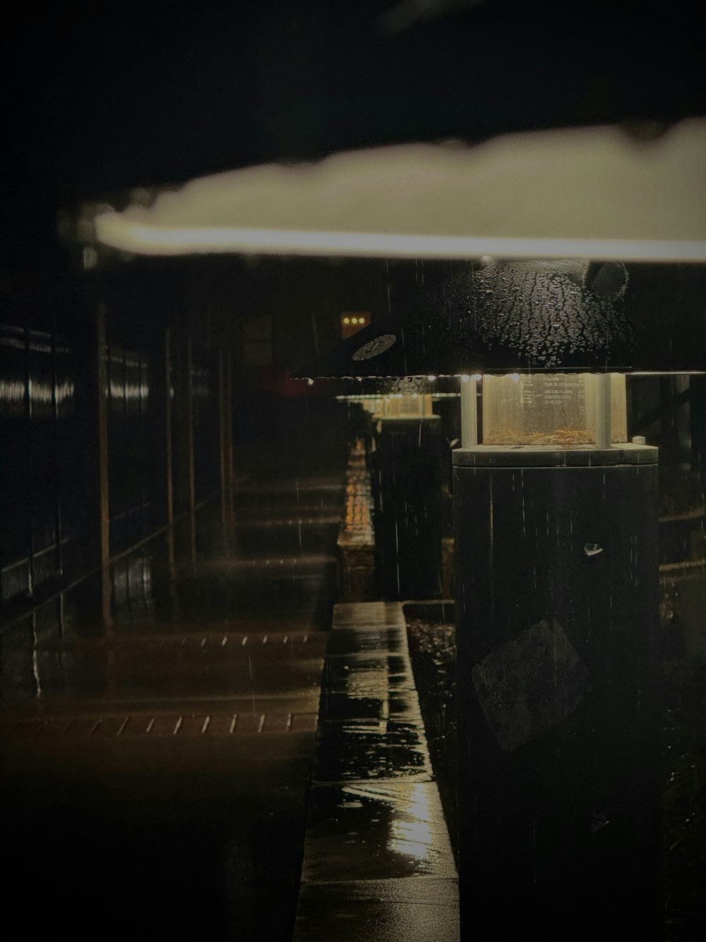 a wet sidewalk next to a building at night