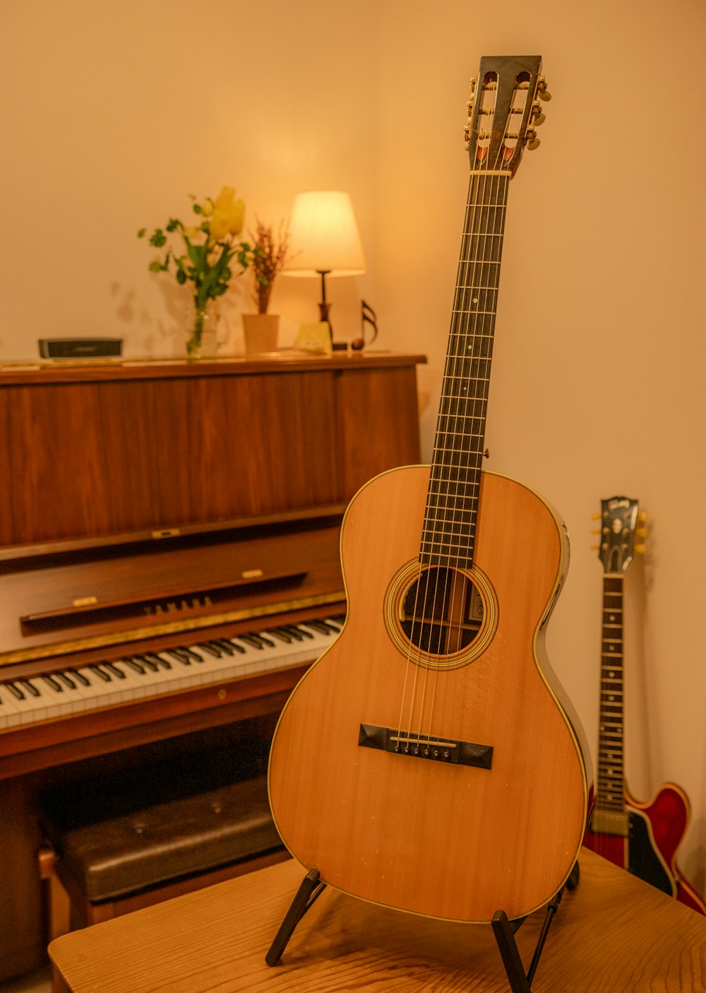 a guitar sitting on top of a table next to a piano