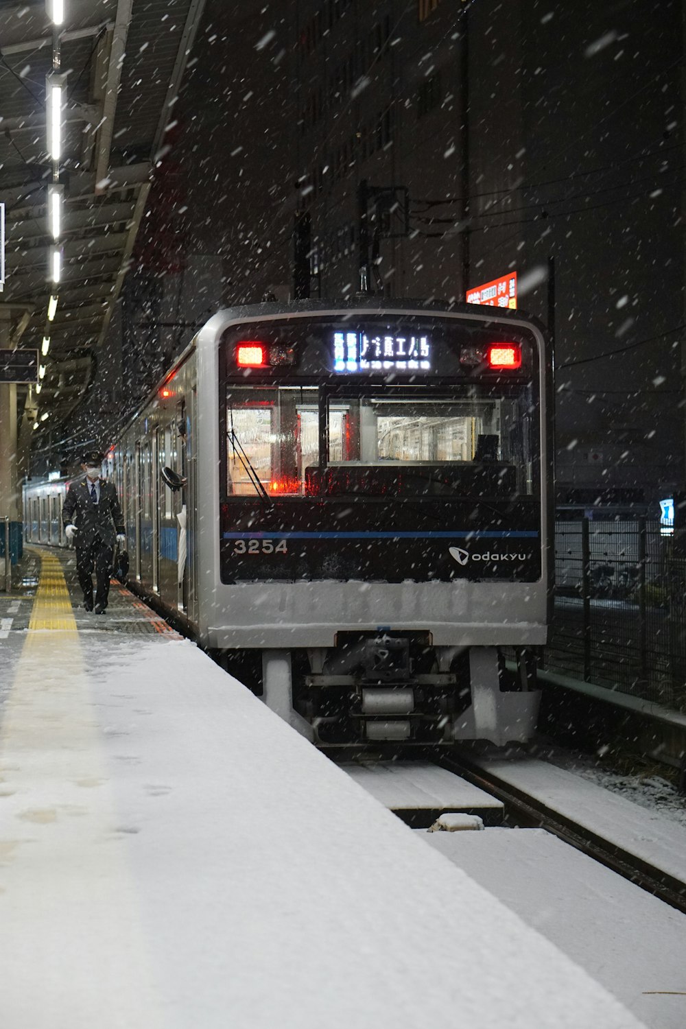 a train pulling into a train station covered in snow