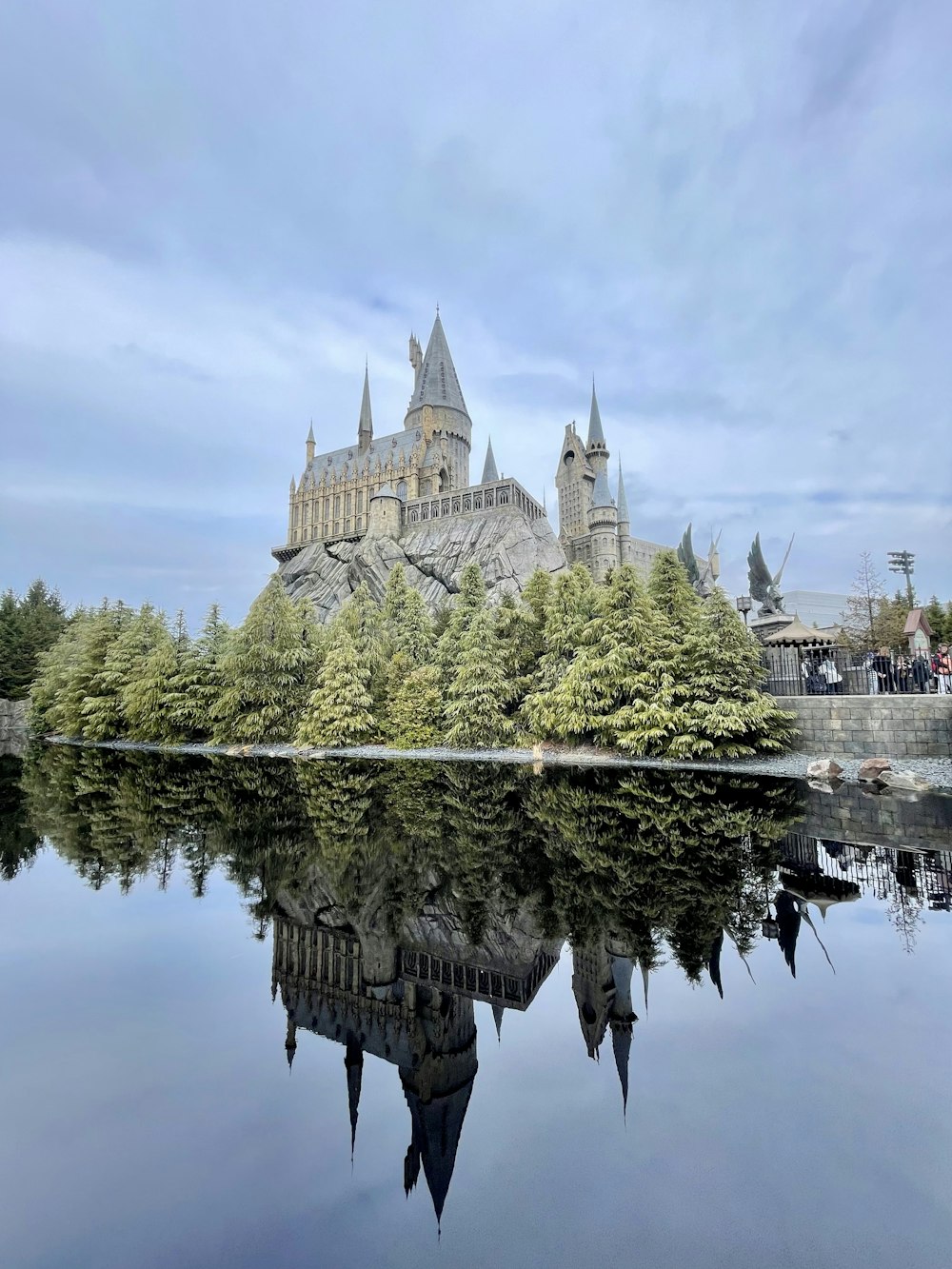 a castle is reflected in the still water of a lake