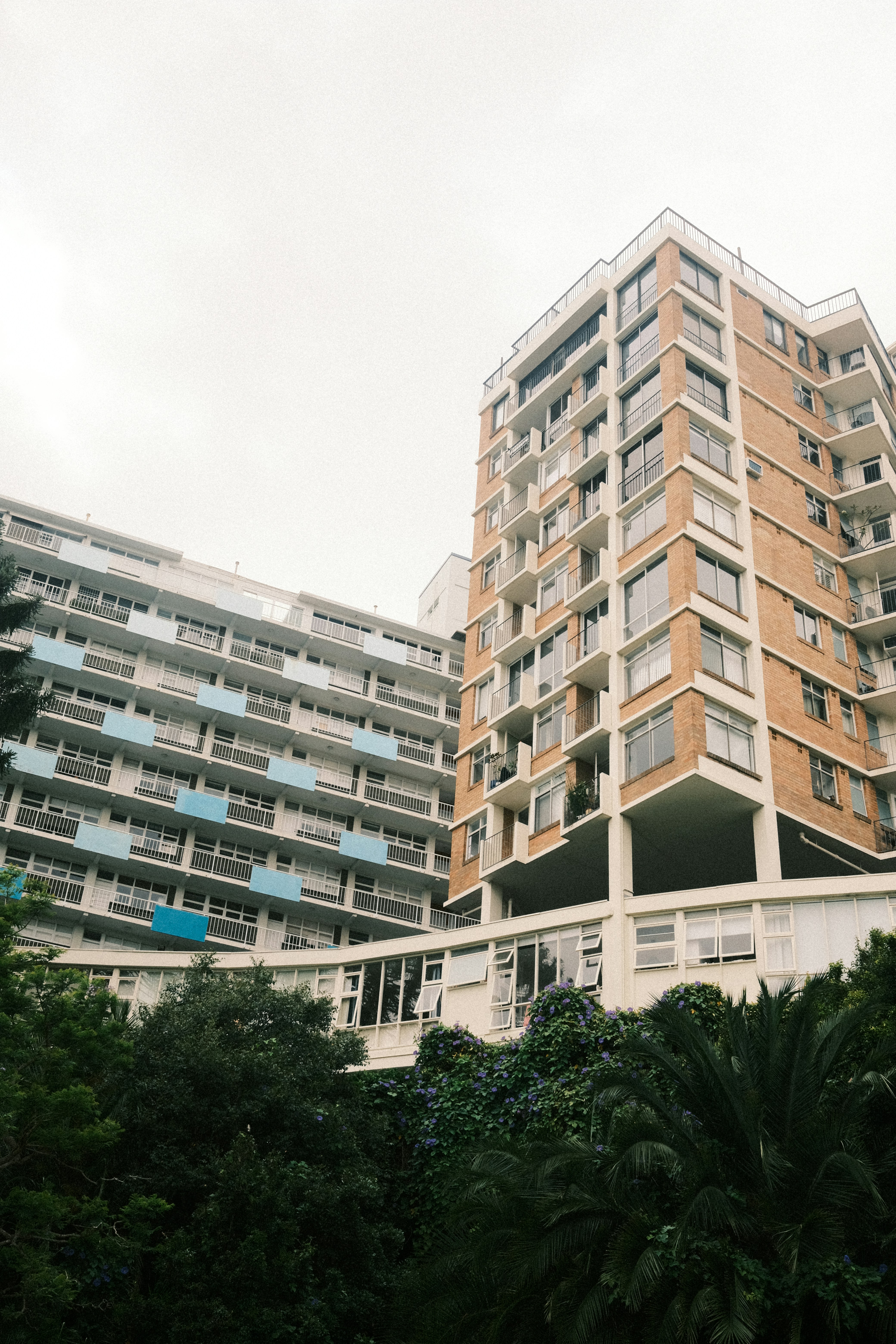 a tall building sitting next to a lush green forest