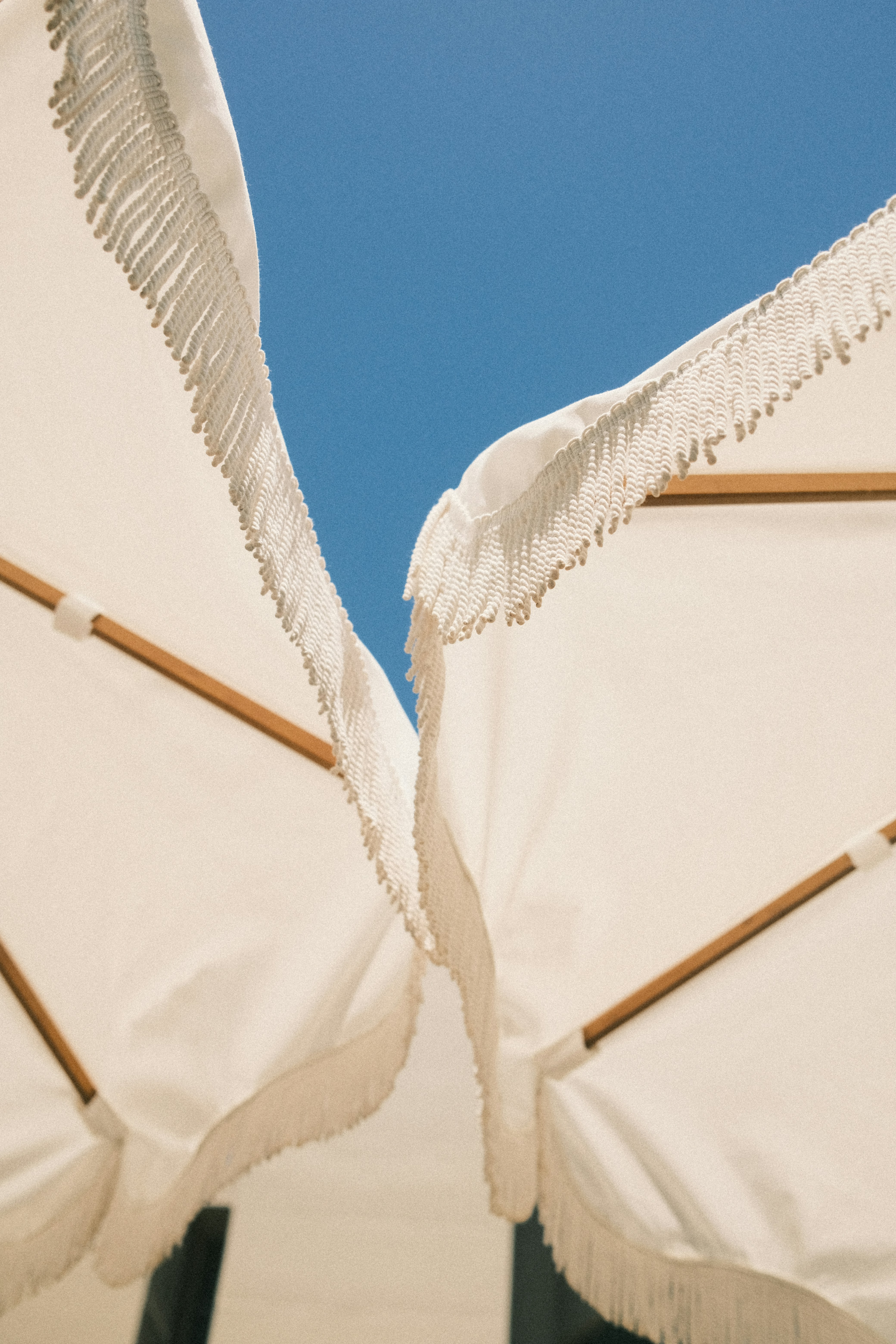 two white umbrellas with white fringes on them