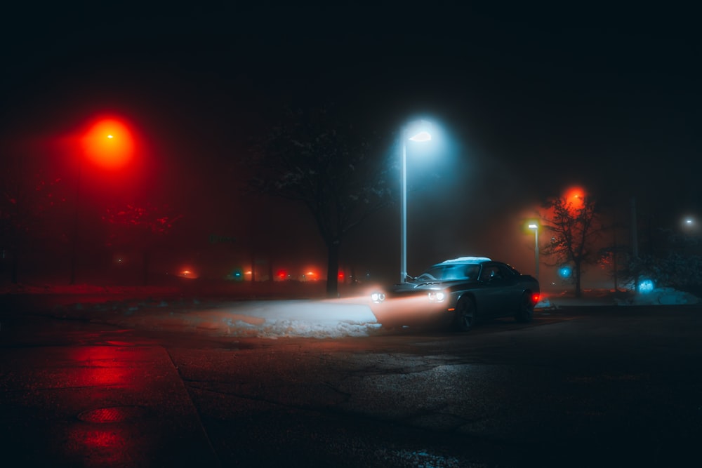 a car driving down a street at night