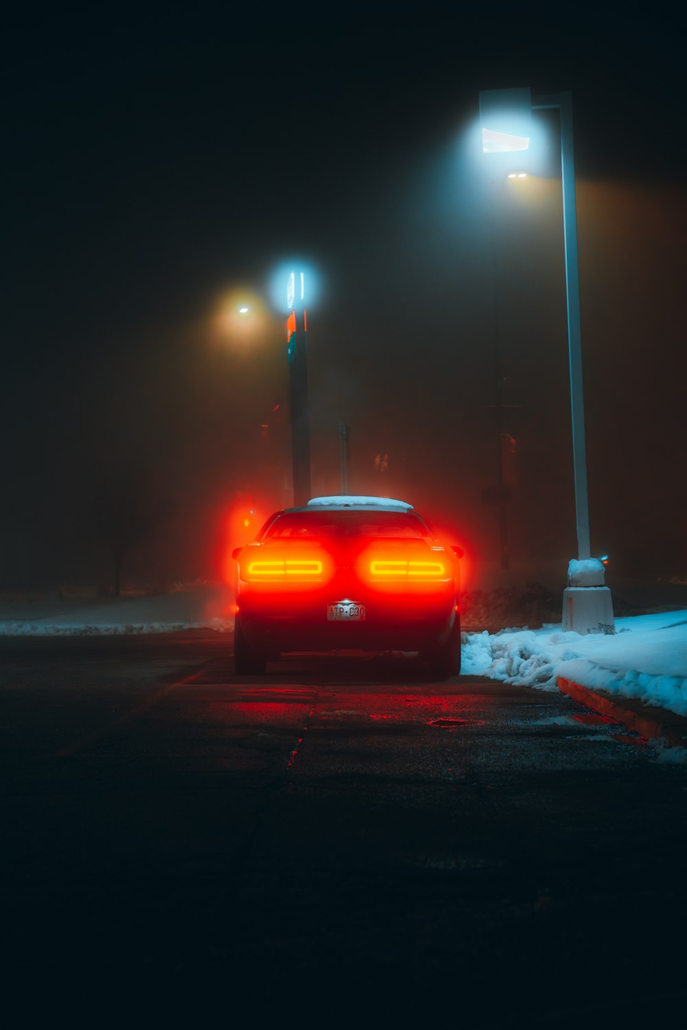 a red car parked in a parking lot at night