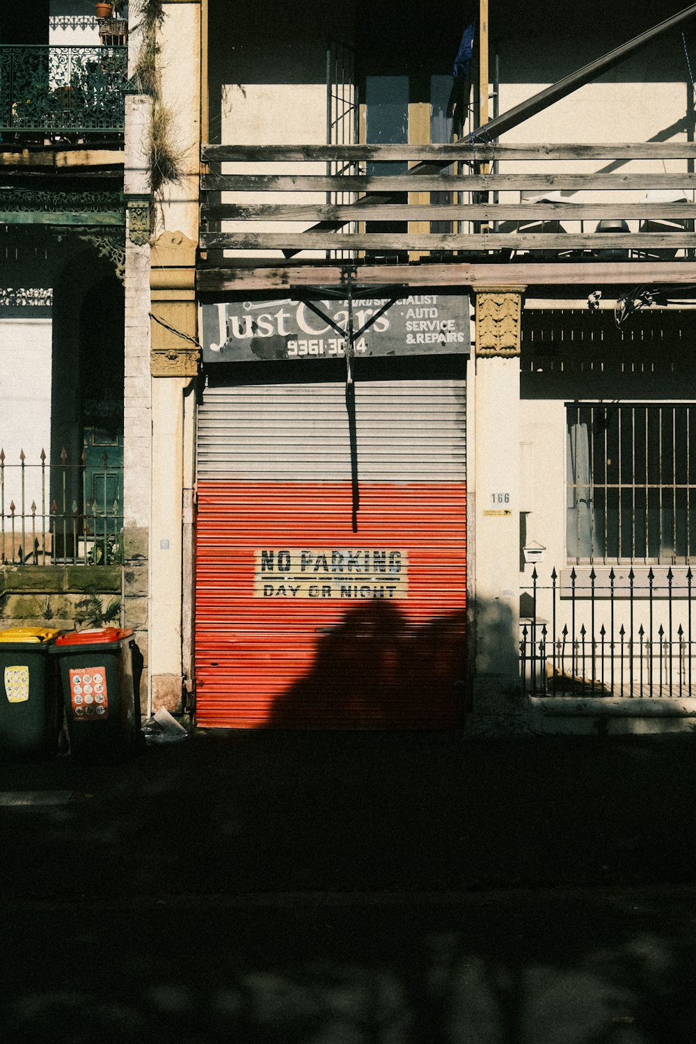 a red garage door sitting next to a tall building