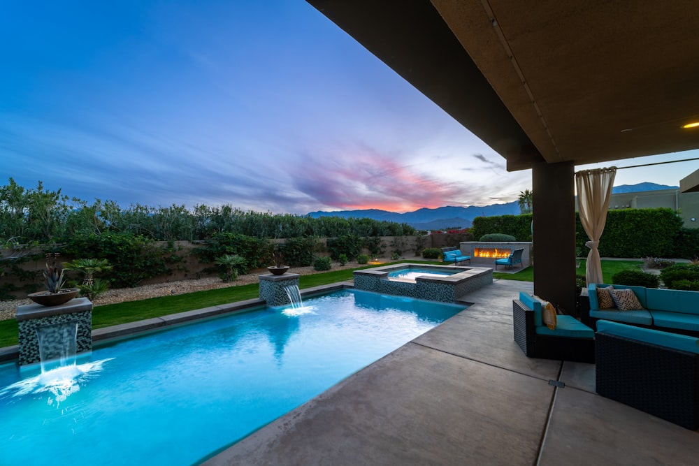 a backyard with a pool and patio furniture