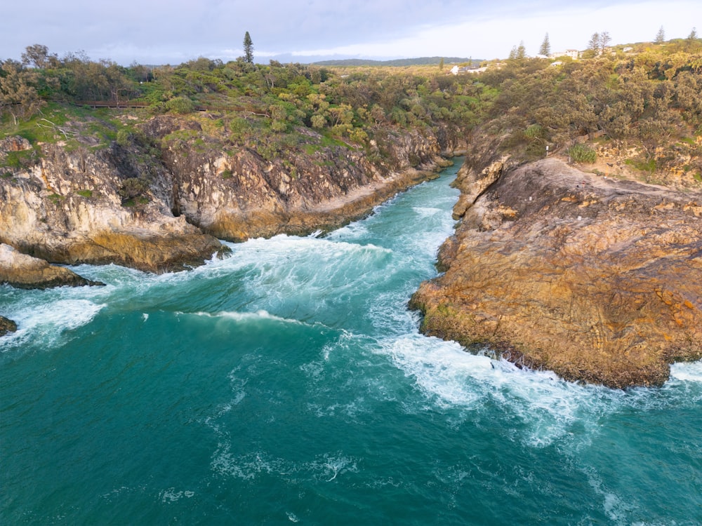 an aerial view of a river flowing between two large rocks